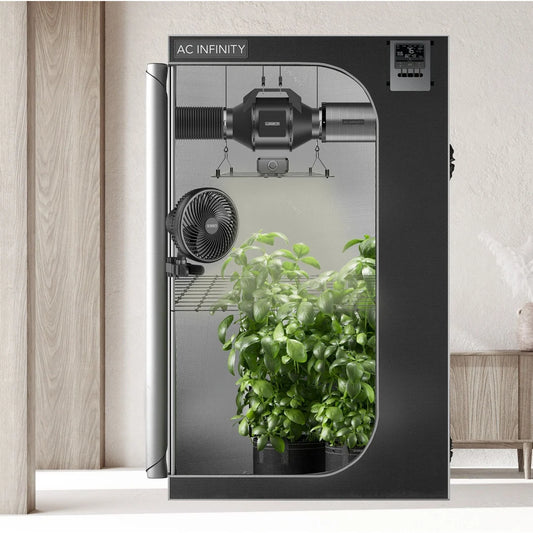 AC Infinity 5x5 grow tent kit set up in a room with plants growing inside