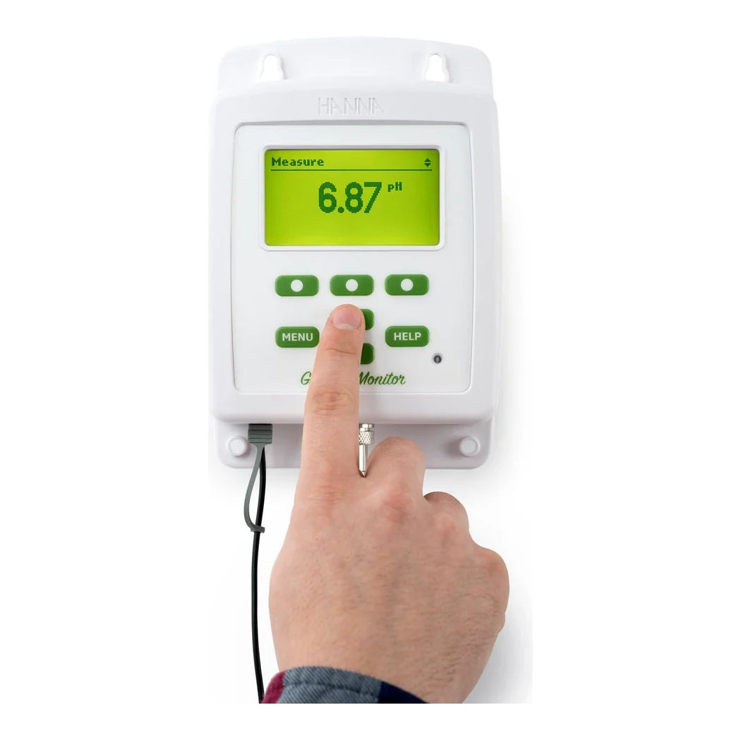Grower pressing a key on the Hanna GroLine HI981420 monitor, display reading 6.87 pH